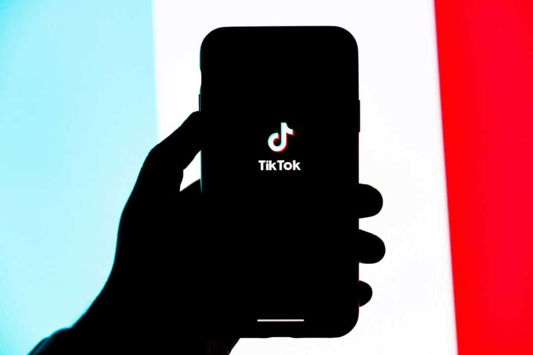Smartphone mit dem TikTok-Logo vor einem farbigen Hintergrund