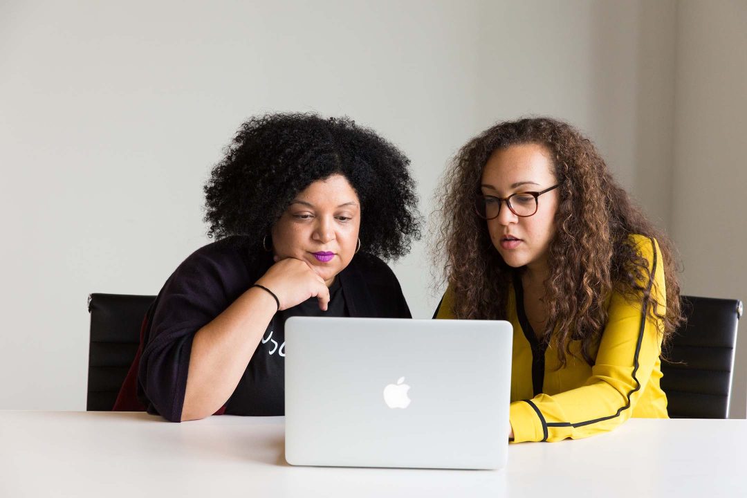 Corporate Influencer – zwei Frauen sitzen gemeinsam vor einem Laptop