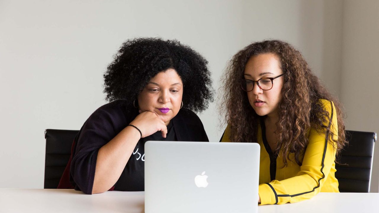 Corporate Influencer – zwei Frauen sitzen gemeinsam vor einem Laptop